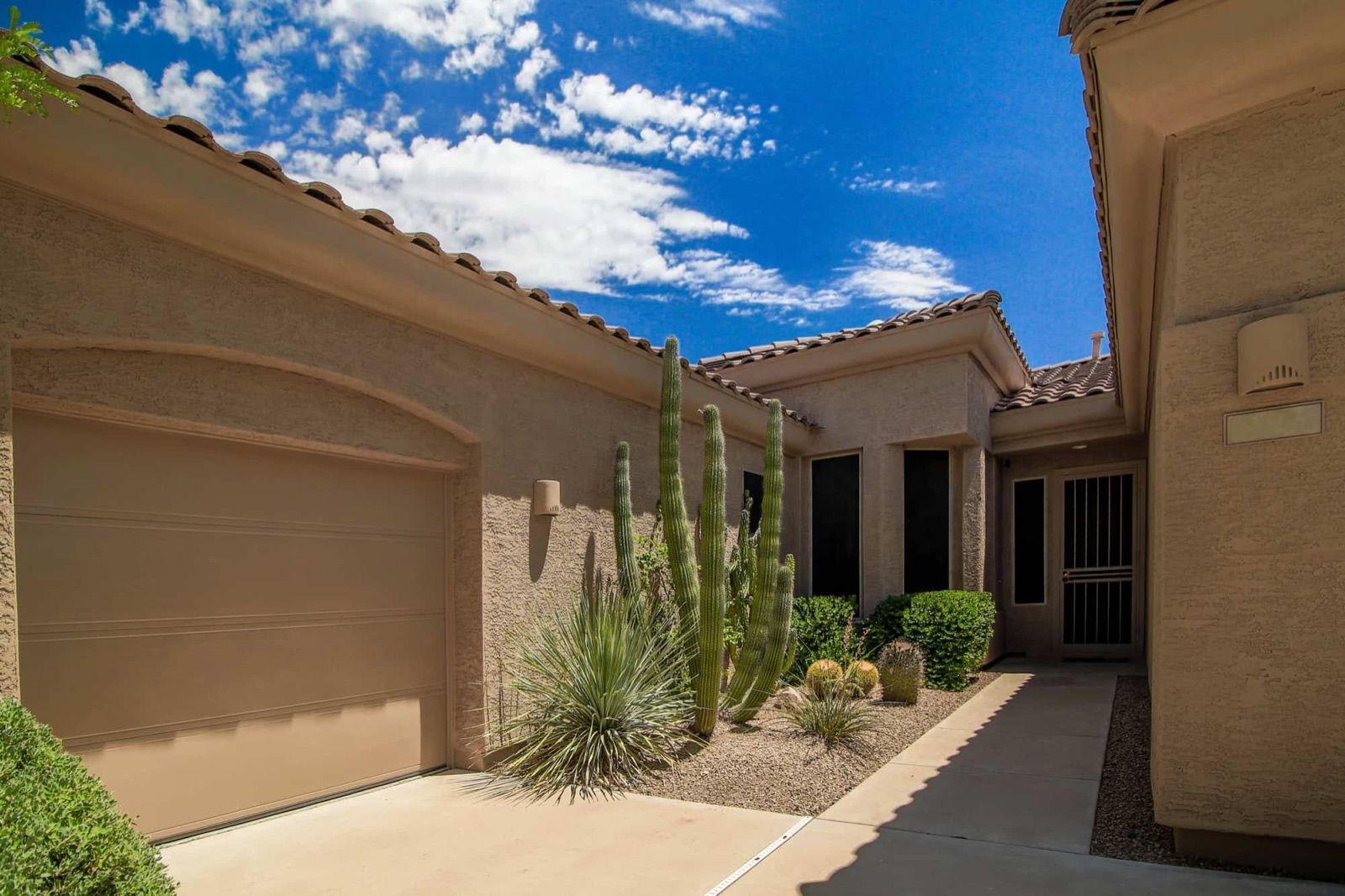 Stucco home with a tile roof and desert landscaping