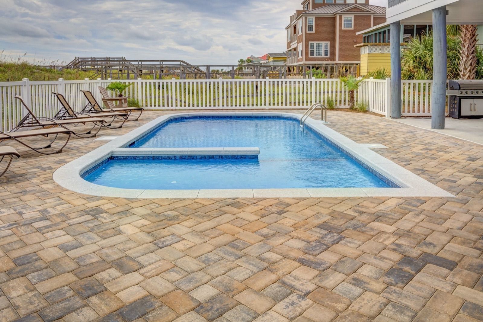 Pool with clear water beside a paver deck